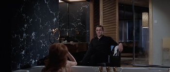 Movie still from “Thunderball” (1965), directed by Terence Young – A man sitting in front of a mirror in a room; Medium shot, High angle