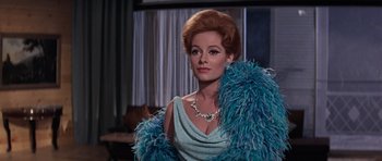 Movie still from “Thunderball” (1965), directed by Terence Young – A woman in a blue dress and a blue boa; Close Up shot, Low angle