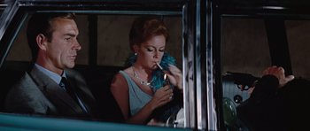 Movie still from “Thunderball” (1965), directed by Terence Young – A woman smoking a cigarette while sitting in a car; Medium shot, Low angle