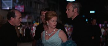 Movie still from “Thunderball” (1965), directed by Terence Young – A woman in a blue dress and a man in a black suit; Medium shot, Over the shoulder angle