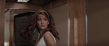 Movie still from “Thunderball” (1965), directed by Terence Young – A beautiful woman with long brown hair wearing a white top; Close Up shot, Low angle