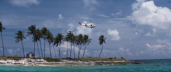 Movie still from “Thunderball” (1965), directed by Terence Young – An airplane flying over the water near some palm trees; Extreme Wide shot, High angle