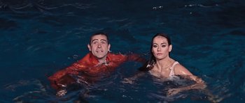 Movie still from “Thunderball” (1965), directed by Terence Young – A man and a woman swimming in a body of water; Medium shot, High angle