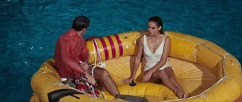Movie still from “Thunderball” (1965), directed by Terence Young – A man and a woman sitting on a raft in the water; Wide shot, High angle