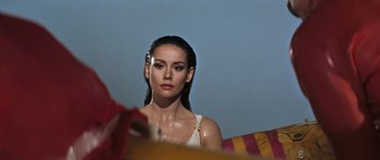 Movie still from “Thunderball” (1965), directed by Terence Young – A beautiful young woman with long dark brown hair; Close Up shot, Over the shoulder angle