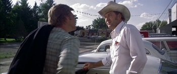 Movie still from “Thunderbolt and Lightfoot” (1974), directed by Michael Cimino – A man wearing a cowboy hat talking to another man; Medium shot, Over the shoulder angle