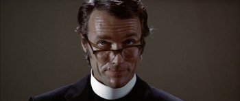 Movie still from “Thunderbolt and Lightfoot” (1974), directed by Michael Cimino – A person wearing glasses and a suit; Close Up shot, Low angle