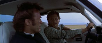 Movie still from “Thunderbolt and Lightfoot” (1974), directed by Michael Cimino – A man and a woman sitting in the back seat of a car; Close Up shot, Over the shoulder angle