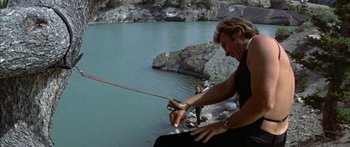 Movie still from “Thunderbolt and Lightfoot” (1974), directed by Michael Cimino – A man holding a fishing pole while standing on a rock; Wide shot, Low angle