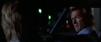 Movie still from “Thunderbolt and Lightfoot” (1974), directed by Michael Cimino – A person is sitting in a car in the dark; Close Up shot, Over the shoulder angle