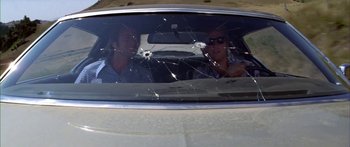 Movie still from “Thunderbolt and Lightfoot” (1974), directed by Michael Cimino – Two people in a car with a broken windshield; Medium shot, Low angle