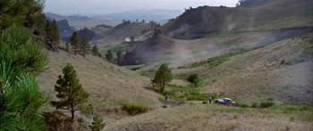 Movie still from “Thunderbolt and Lightfoot” (1974), directed by Michael Cimino – A view of a grassy area with trees in the background; Extreme Wide shot, High angle