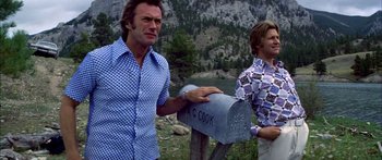 Movie still from “Thunderbolt and Lightfoot” (1974), directed by Michael Cimino – Two men standing next to a mail box in the mountains; Medium shot, Low angle