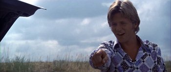 Movie still from “Thunderbolt and Lightfoot” (1974), directed by Michael Cimino – A man pointing at the camera in a grassy field; Close Up shot, Low angle