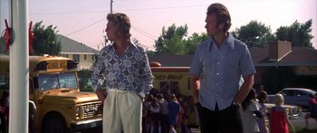 Movie still from “Thunderbolt and Lightfoot” (1974), directed by Michael Cimino – Two men standing next to each other in front of a bus; Medium shot, Low angle