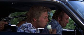 Movie still from “Thunderbolt and Lightfoot” (1974), directed by Michael Cimino – A man in a car eating a cone of ice cream; Close Up shot, Over the shoulder angle