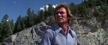 Movie still from “Thunderbolt and Lightfoot” (1974), directed by Michael Cimino – A person wearing a shirt near some trees; Close Up shot, Low angle