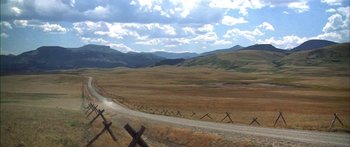 Movie still from “Thunderbolt and Lightfoot” (1974), directed by Michael Cimino – A dirt road going through the middle of a field; Extreme Wide shot, High angle