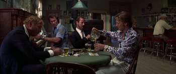 Movie still from “Thunderbolt and Lightfoot” (1974), directed by Michael Cimino – A group of men sitting at a table with drinks; Medium shot, Low angle