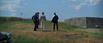 Movie still from “Thunderbolt and Lightfoot” (1974), directed by Michael Cimino – A group of men standing on top of a grass covered hill; Extreme Wide shot, Over the shoulder angle