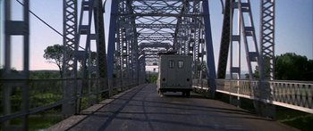 Movie still from “Thunderbolt and Lightfoot” (1974), directed by Michael Cimino – A truck driving across a bridge over a river; Extreme Wide shot, Low angle