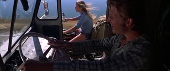 Movie still from “Thunderbolt and Lightfoot” (1974), directed by Michael Cimino – Two people riding bikes in the back of a truck; Wide shot, Low angle