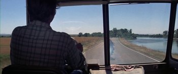 Movie still from “Thunderbolt and Lightfoot” (1974), directed by Michael Cimino – A man sitting on a bus looking out the window; Wide shot, Over the shoulder angle