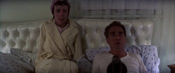 Movie still from “Thunderbolt and Lightfoot” (1974), directed by Michael Cimino – A man and a woman sitting on a couch in a room; Medium shot, Low angle