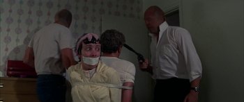 Movie still from “Thunderbolt and Lightfoot” (1974), directed by Michael Cimino – A woman tied to a chair with a rope around her neck; Medium shot, Over the shoulder angle