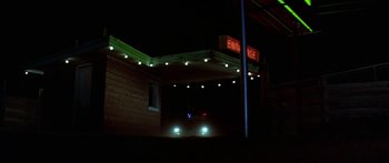 Movie still from “Thunderbolt and Lightfoot” (1974), directed by Michael Cimino – A car parked in front of a building at night; Wide shot, Low angle