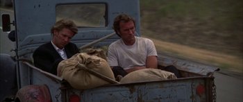 Movie still from “Thunderbolt and Lightfoot” (1974), directed by Michael Cimino – A man sitting in the back of a blue truck; Medium shot, Low angle