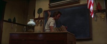 Movie still from “Thunderbolt and Lightfoot” (1974), directed by Michael Cimino – A man standing in front of an open book; Medium shot, Low angle