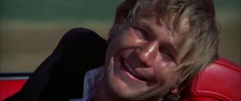 Movie still from “Thunderbolt and Lightfoot” (1974), directed by Michael Cimino – A man smiling for the camera; Close Up shot, Low angle