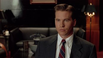 Movie still from “Thunderheart” (1992), directed by Michael Apted – A man wearing a suit and tie in a restaurant; Close Up shot, Over the shoulder angle