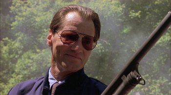 Movie still from “Thunderheart” (1992), directed by Michael Apted – A person wearing sunglasses and holding a gun; Close Up shot, Low angle