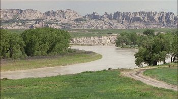 Movie still from “Thunderheart” (1992), directed by Michael Apted – A river running through the middle of a field; Extreme Wide shot, High angle