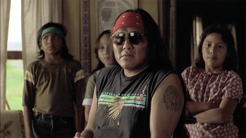 Movie still from “Thunderheart” (1992), directed by Michael Apted – A man with a red bandanna on his head; Medium shot, Over the shoulder angle