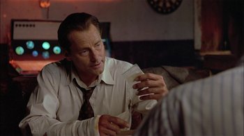 Movie still from “Thunderheart” (1992), directed by Michael Apted – A man in a white dress shirt and a red neck tie; Close Up shot, Over the shoulder angle