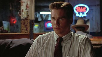 Movie still from “Thunderheart” (1992), directed by Michael Apted – A man in a striped dress shirt and a tie; Close Up shot, Over the shoulder angle