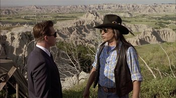Movie still from “Thunderheart” (1992), directed by Michael Apted – A man in a cowboy hat and a man in a suit talking to each other; Medium shot, Over the shoulder angle
