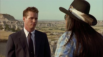 Movie still from “Thunderheart” (1992), directed by Michael Apted – A man in a suit talking to a man in a cowboy hat; Medium shot, Over the shoulder angle