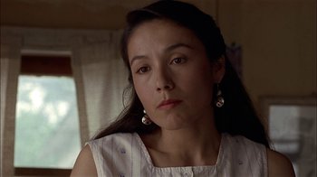 Movie still from “Thunderheart” (1992), directed by Michael Apted – A person with long hair wearing a dress; Close Up shot, Over the shoulder angle