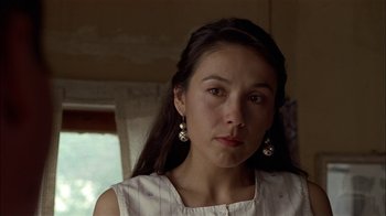 Movie still from “Thunderheart” (1992), directed by Michael Apted – A woman with long dark brown hair wearing a white shirt; Close Up shot, Over the shoulder angle