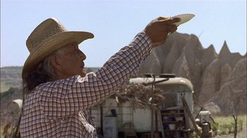 Movie still from “Thunderheart” (1992), directed by Michael Apted – An older man holding a frisbee in his hand; Medium shot, Low angle