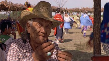 Movie still from “Thunderheart” (1992), directed by Michael Apted – An old man wearing a cowboy hat holding a toothbrush; Close Up shot, Over the shoulder angle