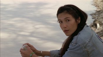 Movie still from “Thunderheart” (1992), directed by Michael Apted – A woman holding a plastic bottle in her hand; Close Up shot, High angle