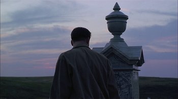 Movie still from “Thunderheart” (1992), directed by Michael Apted – A man standing in front of an old cemetery; Wide shot, Low angle