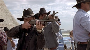 Movie still from “Thunderheart” (1992), directed by Michael Apted – A group of men standing next to each other holding guns; Medium shot, Low angle