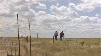 Movie still from “Thunderheart” (1992), directed by Michael Apted – Two men are standing in a field looking at the sky; Extreme Wide shot, Low angle