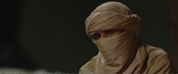 Movie still from “Timbuktu” (2014), directed by Abderrahmane Sissako – A man wearing a head covering is looking at the camera; Close Up shot, Over the shoulder angle